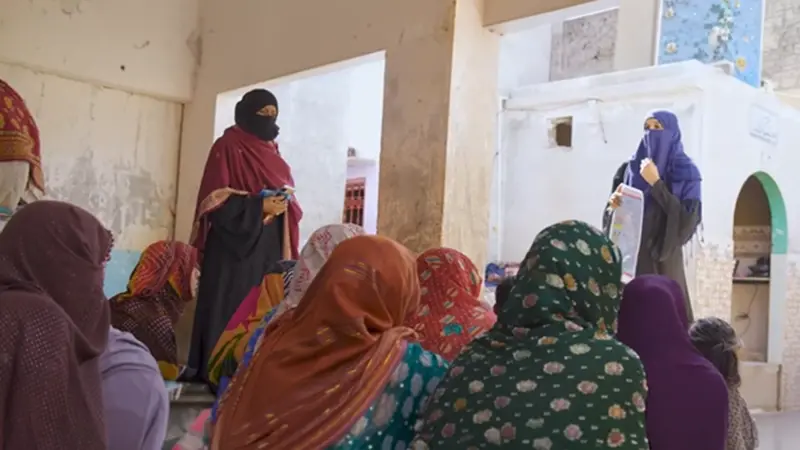 Community health workers teaching a group of women in a rural village how to prevent sand fly bites